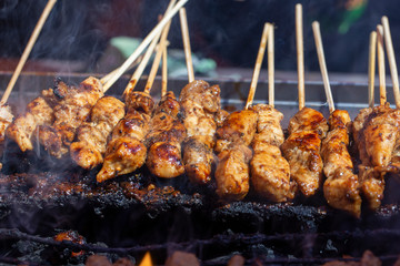 Thai street vendor sells grilled chicken meat at street food market in Thailand. Close up