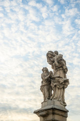 Fototapeta na wymiar Saint Anne statue on Charles Bridge in Prague, Czech Republic. Medieval Gothic bridge, finished in the 15th century, crossing the Vltava River