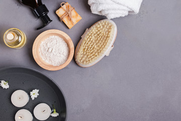 Spa still life with different body and skin care essentials and bowl with floating candles