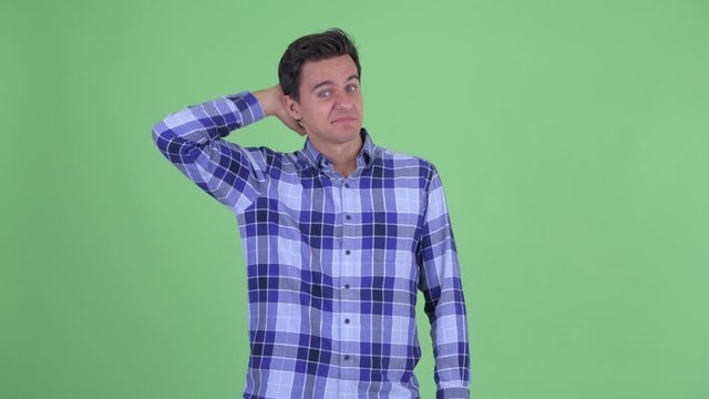 Confused young handsome hipster man scratching head