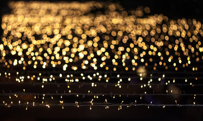 Fires of a Christmas garland which is suspended horizontally are dissolved by a gradient in a bokeh (blur).