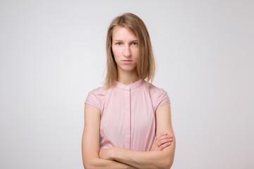 Dissatisfied young woman looking angrily at camera, showing irritated face expression