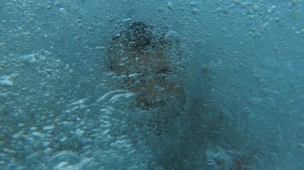 Handsome young man jumping from a boat or yacht into the sea or ocean. Summer vacation with friends. Tourists have fun and dive. Slow motion.