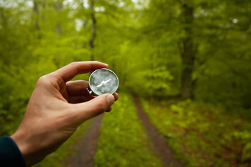 man hand compass in forest