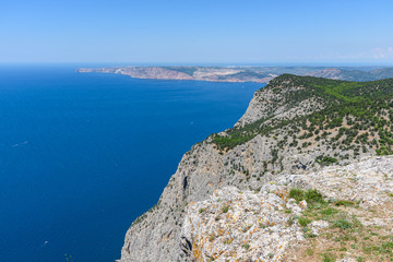 Fototapeta na wymiar view of the Black Sea from the height of Mount Ayia, a cape on the southern coast of the Crimea, to the south-east of Balaclava. Sunny bright day with clouds on the sky. Spring view of the Crimea.