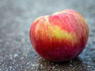 Freshly plucked red Apple close-up lying on the table