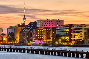 Fototapeten Dramatic sunset at the river Spree in Berlin with the Television Tower in the back © elxeneize