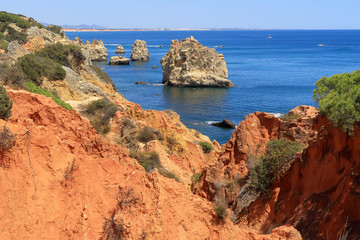 Fototapeta na wymiar The red rocky and jagged coastline overlooking the Atlantic Ocean near Albufeira
