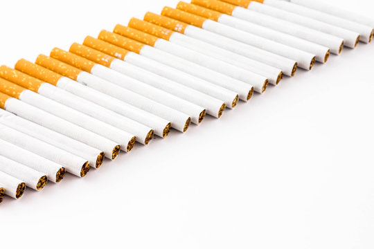 Hilera de cigarrillos en diagonal sobre fondo blanco.