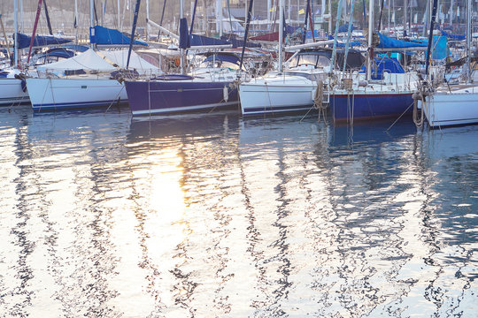 Sea surface in marina - sunlight and reflections on water. Abstract background for your concept of the sea vacation. Yacht parking in harbor, harbor yacht club.