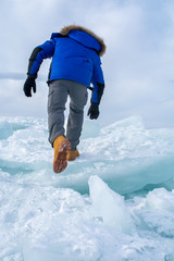 Fototapeta na wymiar Man walking on ice in frozen lake at Lake Bikal, Russia