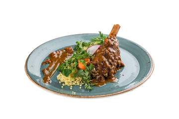 Braised lamb shanks with couscous on blue plate isolated on white background