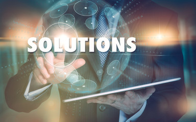 A hand selecting a Solutions business concept on a futuristic computer display.