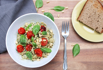 Orzo rice with pesto and caramelised cherry tomatoes and topped with basil leafs. 