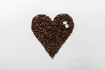 top view of heart made of coffee grains with sugar on white background