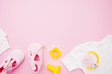 Flat lay baby clothes with pink background