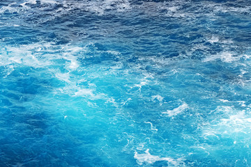 Shot of sea of ocean surface with moving water making foam .