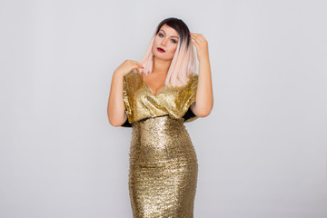 Portrait of a beautiful blonde with bright makeup in a gold dress