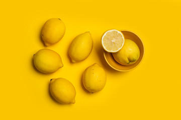 . CopyLimones enteros y por la mitad sobre un fondo amarillo brillante y aislado. Vista superior y de cerca. Copy space
