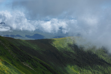 clouds soar over a beautiful view of a mountain range