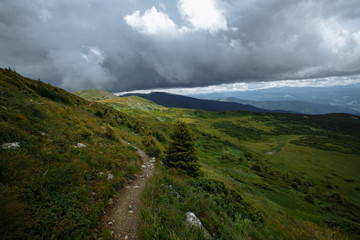 rainy clouds over the panorama of summer mountains