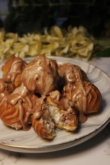 Profiteroles with chocolate on plate