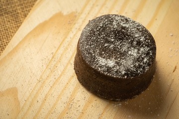 Chocolate fondant with icing sugars on top, on a black slate plate, selective focus