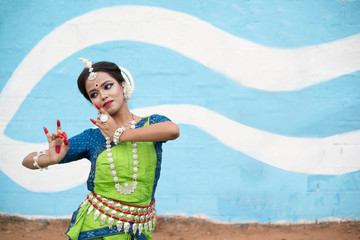 Indian classical odissi dancer wears traditional costume posing Mudra or Hand Gestures.