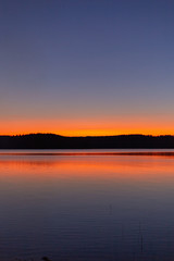 Lake sunset silhouette. Finnish lake landscape photo.