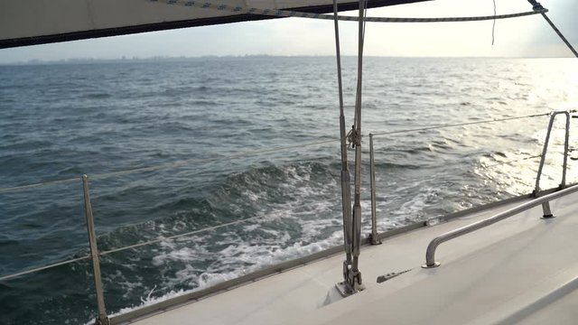 Sailing yacht on the waves in the Black Sea at sunset