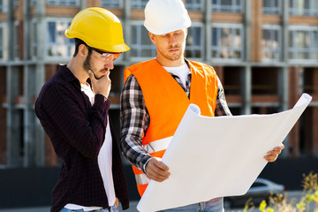 Medium shot of architect and engineer looking at plans