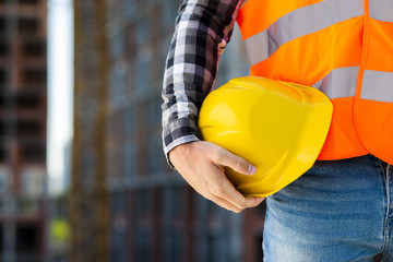 Close-up construction worker holding helmet