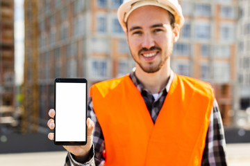 Medium shot portrait of construction engineer holding phone