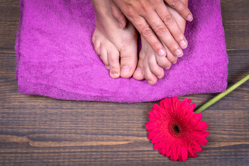 Obraz na płótnie Canvas Pedicure. Women's legs and hands on the background of towel and flowers