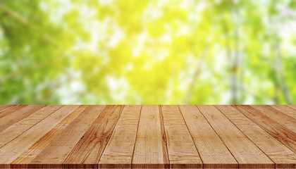 Naklejka na ściany i meble Empty wooden table with blur of green nature background