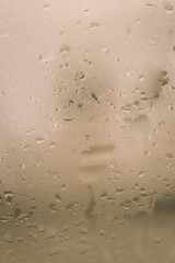 Rain Drops On Surface of wet Window Glass pane In Rainy Season. Abstract background. Natural Pattern of raindrops isolated from outdoor cloudy environment.