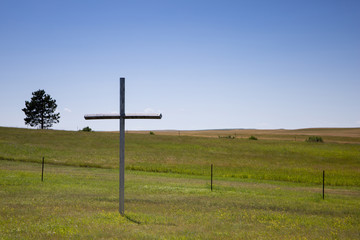 Single cross in the middle of rural North Dakota outside a small cemetery  - Powered by Adobe