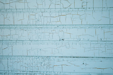 Textured wall with cracked paint in a turquoise aqua color found in an old house