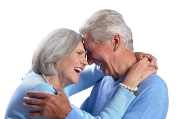 happy senior couple embracing and posing on white background