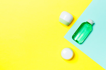 Group of plastic bodycare bottle Flat lay composition with cosmetic products on yellow and blue background empty space for you design. Set of White Cosmetic containers, top view with copy space