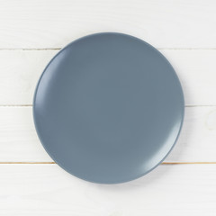 Top view with empty for you design. Empty grey plate on wooden background