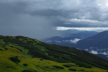 Fototapeta na wymiar rain high in the mountains floods half the panorama of the mountains
