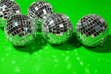 Shiny party disco balls shining in a day light over color background