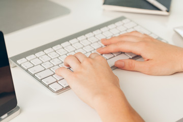 Close up of a female hands of  woman office worker typing on the keyboard