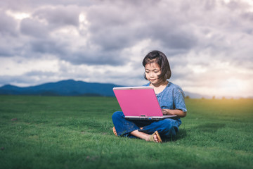 Asian children in local dress are using laptop for education and communication at countryside of Thailand.