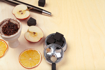 Parts of hookah and fruits on wooden background