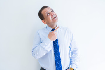Middle age business man smiling and pointing to the side over white background