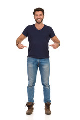 Smiling Young Man Is Pointing At His Blue T-shirt