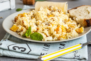 Cauliflower rice with vegetables (onion and bell pepper). Organic paleo cauliflower rice on grey concrete  background. Copy space. Healthy concept.