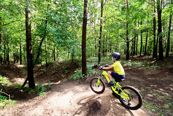 Fototapeta na wymiar Young boy riding in the wild forest.